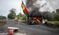 An Indigenous Kanak flag stands next to a burning vehicle at a roadblock at La Tamoa, in the commune of Paita, New Caledonia.