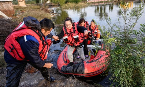 Rescuers evacuating residents in a flooded area after heavy rain in Jiexiu, Shanxi province, China