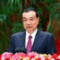 Li Keqiang seated behind microphone and flowers