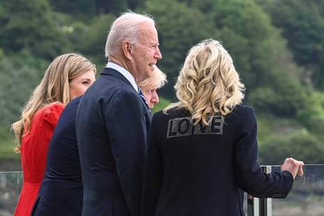 Jill Biden wearing a jacket with the word “Love” on its back. She is standing next to her husband, Joe Biden, Boris Johnson, and his wife Carrie Johnson at Carbis Bay.