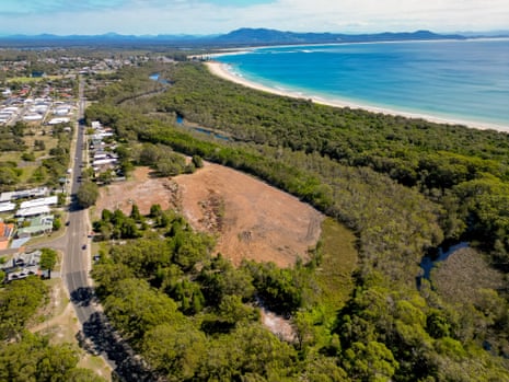 Aerial view of cleared site in bushland on between the edge of a town and the beach