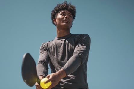 A pickleball player ready to serve in a game