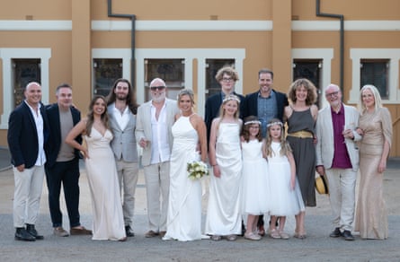 A bride, groom and their blended family pose for a wedding photo.