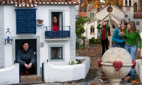 Visitors look at, and hide in, miniature white houses that are part of the Portuguese theme park and attraction Portugal do Pequenitos in Coimbra, Portugal.
