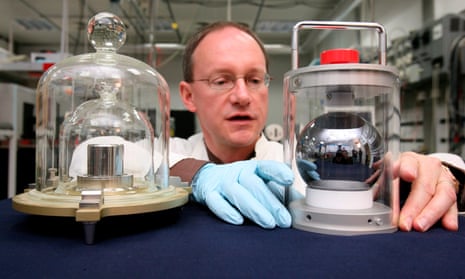 Arnold Nicolaus, of the Physical-Technical Federal Agency, shows a silicon ball next to a copy of the kilogram prototype in Brunswick, Germany.