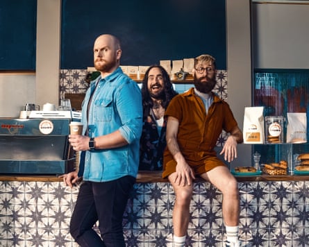 Three men in a cafe pulling funny faces