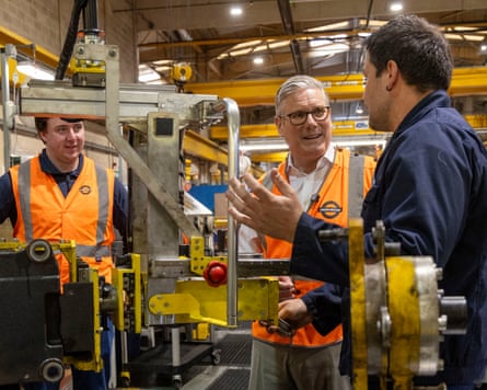 Keir Starmer talking to two young men in a workshop