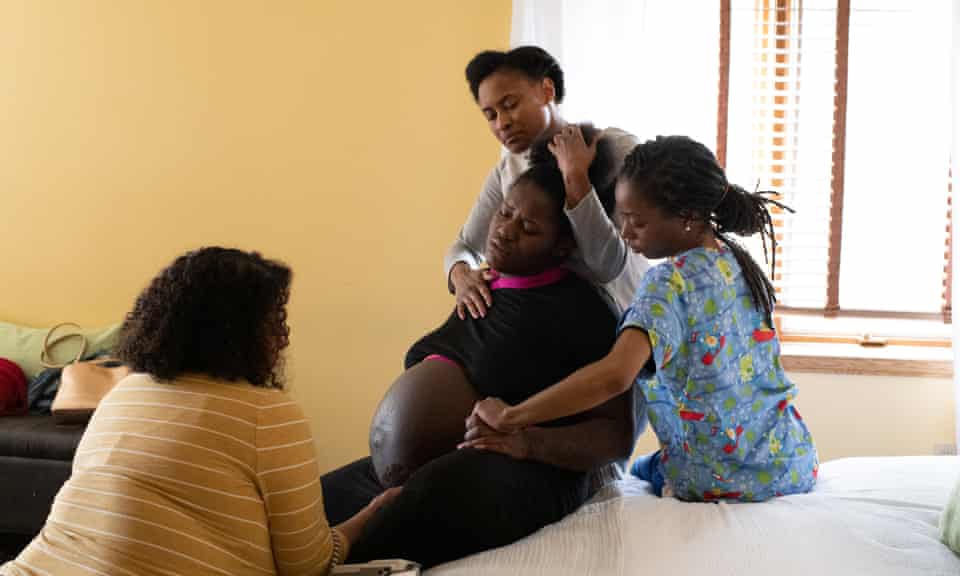 Midwife Rebecca Polston watches Em’Mae Alexander labor with the support of her mother, Tulani Alexander and her doula, Lakesha Gordon at Roots Community Birth Center.