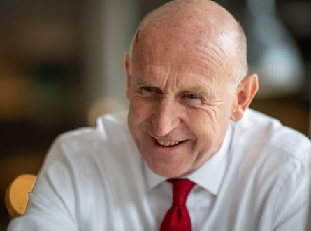 John Healey in a shirt and tie during a visit to a holiday centre in Tenby