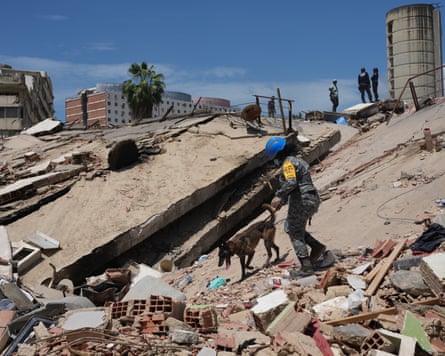 A rescue worker from Mexico and a sniffer dog search through the rubble of a collapsed building in La Guaira on Saturday.