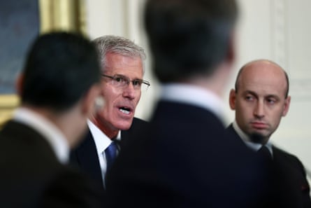 A man seen over the shoulders of other men in suits.