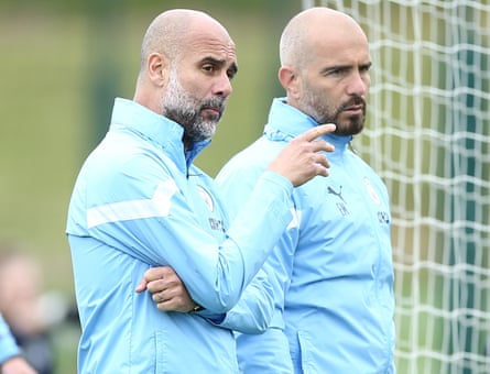 The Manchester City manager, Pep Guardiola (left), speaks to his adjunct head Enzo Maresca during a training convention successful June 2023.