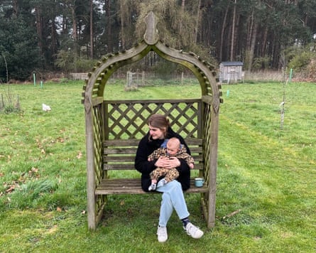 They sit in an ornate wooden love seat in a garden