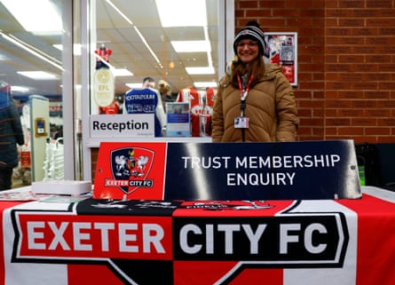 Women behind table with ‘Trust membership enquiry’ and ‘Exeter City FC’ in front