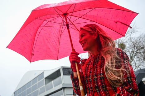 A racegoer sheltering from the rain at Cheltenham.