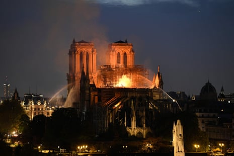 Firefighters douse flames rising from the roof at Notre-Dame Cathedral in Paris.