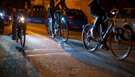 Group of cyclists riding through city streets at night