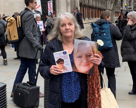 Joy Dove outside the Royal Courts of Justice holding a photo of Jodey Whiting and a book titled A Mother’s Job