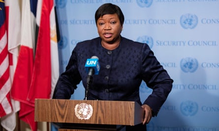 Fatou Bensouda stands next to various national flags at a lectern that features the UN logo.