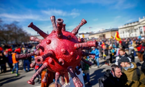 A model of the coronavirus is seen attached to a sign during a protest against the government’s coronavirus disease (COVID-19) restrictions in Kassel, Germany March 20, 2021.