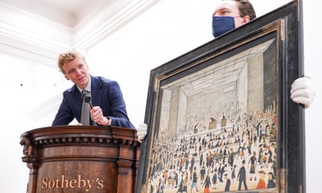 An auctioneer looks at LS Lowry's The Auction on display at Sotheby's London.