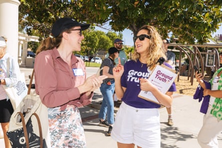 A woman speaks to people on the street.