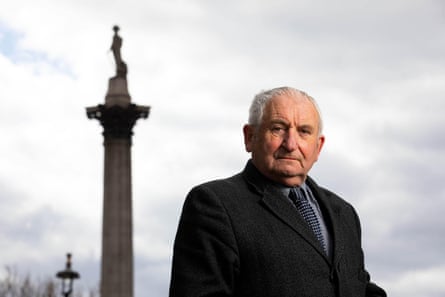 Man stands in front of Nelson’s Column in London.