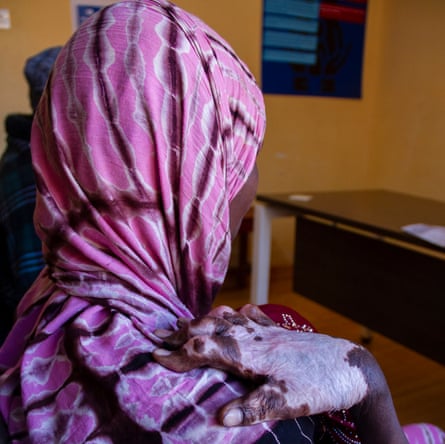 A woman wearing a headscarf looks away from the camera