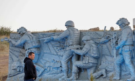 A man stands next to an element of the reconstructed second world war memorial in the Donetsk region, Ukraine.