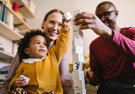 Multi-racial family plays with alphabet blocks including non-standard letters