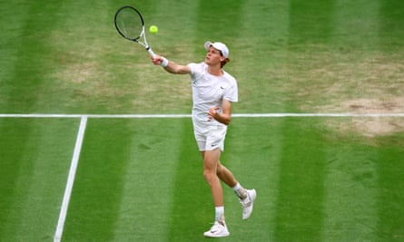 Jannik Sinner strikes the ball back towards Roman Safiullin