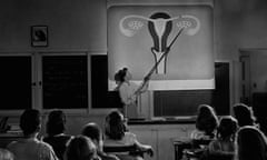 A teacher points to a diagram of female reproductive organs projected on a screen in a classroom in a scene from Human Growth, an education film on sex education shown to students in Oregon junior high schools from 1948.