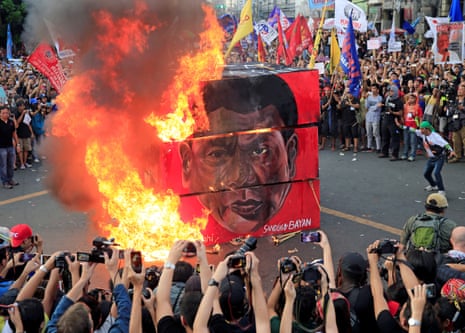 Protesters burn a cube effigy with a face of President Rodrigo Duterte during a National Day of Protest in Manila on 21 September.