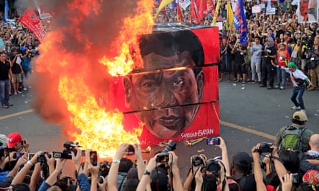 Protesters burn a cube with the face of Rodrigo Duterte during a national day of protest.