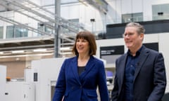 Rachel Reeves in a suit and wearing a thin necklace next to Keir Starmer, with glasses and in a suit with no tie, next to equipment at the Manufacturing Technology Centre in Coventry