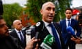 Luis Rubiales speaks to members of the media as he leaves a court in Majadahonda, Spain, 29 April 2024: journalists are thrusting microphones at him and he is speaking; he wears a dark blue suit and tie with white shirt, and is a man in his mid-40s with a shaven, bald head
