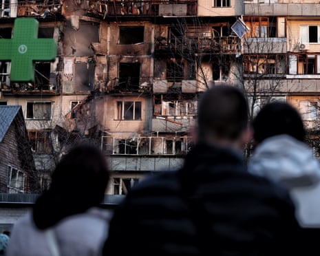 People look on damaged residential building after Russian drone-and-missile attack on Kyiv, Ukraine.