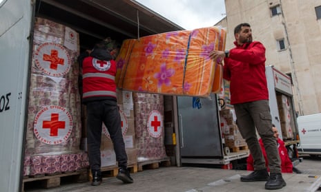 A Görög Vöröskereszt munkatársai február 10-én a görögországi Athénban felraknak egy humanitárius segélyekkel teli teherautót.
