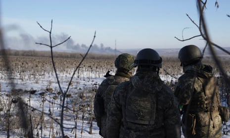 Ukrainian soldiers watch as smoke billows during fighting between Ukrainian and Russian forces in Soledar, Donetsk region, Ukraine.