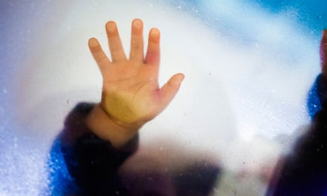 Toddler girl's hand touching glass