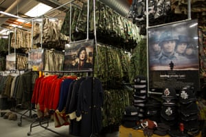 Red coats are hung below the film posters of Black Book and Saving Private Ryan in the stockroom