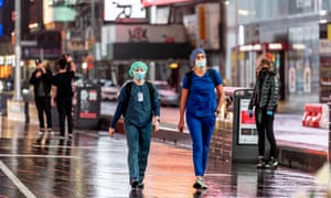 Medical workers wear masks in Times Square on Sunday in New York City.