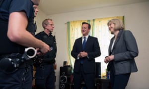 David Cameron, then UK prime minister, and Theresa May, then home secretary, with Home Office officers in 2014 at a house where several migrants were arrested in Berkshire.