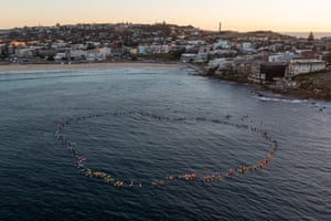 Aerial of people on surfboards in a circle in the sea