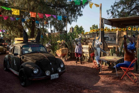 A customised car with rabbit-like ears parked near figures dressed as donkeys at a fair