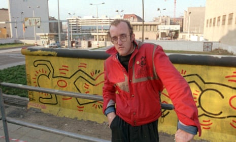 Haring by the Berlin Wall with one of his baby images. October 1986