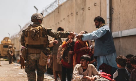 ‘Cheerleading for the war in Afghanistan was almost universal, and dissent was treated as intolerable.’ A US marine with evacuees at Kabul airport. 