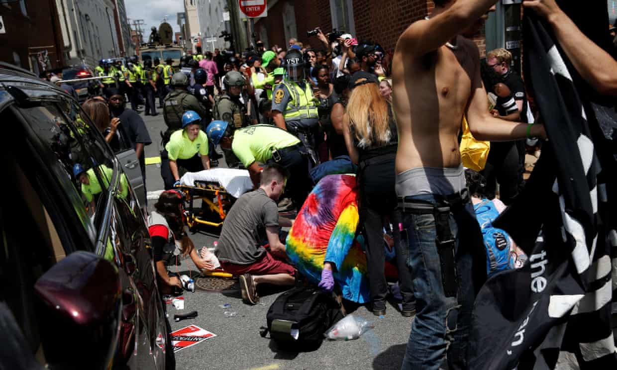 Rescue workers assist people who were injured when a car drove through a group of people in Charlottesville.