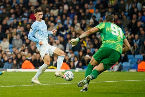 Phil Foden shoots past the goalkeeper to score during a Champions League match