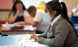 A pupil wears a face mask in a classroom.